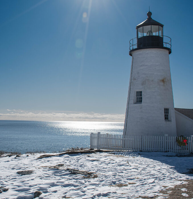 Pemaquid Point Light lighthouse on a snow-covered point on a clear winter day
