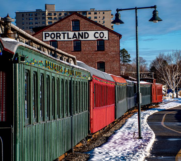 Vintage train cars beside the Portland Company building in winter